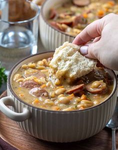 someone is dipping some bread into a bowl of soup