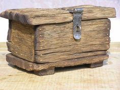 an old wooden box sitting on top of a table next to a metal latchet