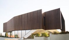 a modern house with large windows and wooden slats on the roof