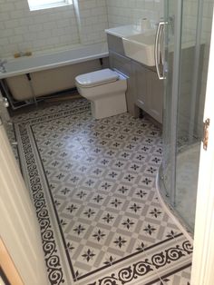 a bathroom with a white toilet sitting next to a walk in shower and a sink