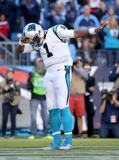 a football player is standing on the field with his arms out and hands in the air