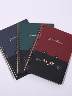 three notebooks with cats on them sitting next to each other