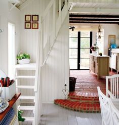 an open kitchen and living room with stairs leading up to the dining area, while another is on the other side of the house