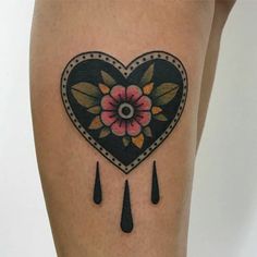 a heart shaped tattoo with flowers and raindrops on the side of her leg