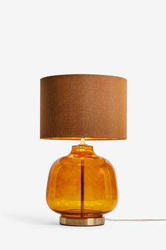 an orange glass table lamp with a brown shade