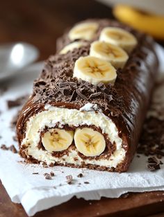 a chocolate roll with bananas and cream on it