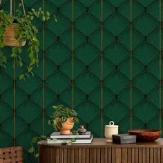 a room with green wallpaper and potted plants on top of a wooden table