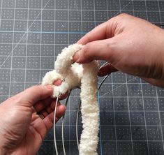 someone is making something out of yarn with scissors