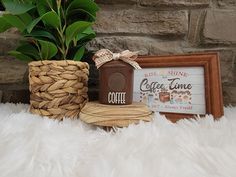 a coffee time sign, potted plant and some other items on a white fluffy surface