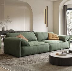 a living room with a green couch and coffee table in front of a large window