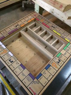 a wooden board game sitting on top of a workbench in a factory or workshop