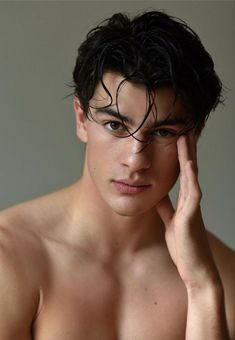 a shirtless young man with his hand on his head looking off to the side