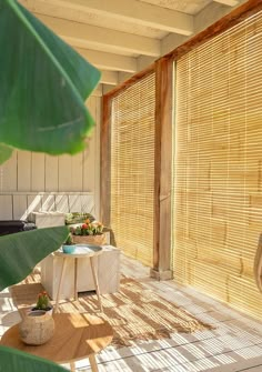 the sun is shining through the bamboo blinds in this room with an outdoor table and chairs