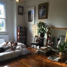 a person laying on top of a bed in a bedroom next to a book shelf