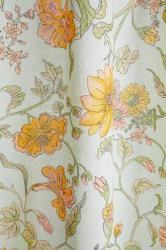 a close up view of a curtain with flowers and leaves on the outside of it