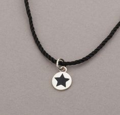 Simple yet stylish, the Silver Star Necklace features a tiny silver disc with a black star on its center. Simple and modern sterling silver star charm on a black string. Wear it any time on its own or mix and match to create trendy looks. PRODUCT DETAILS: The sterling silver disc is 10mm Black string MATERIALS: Sterling Silver Sterling Silver is a solid precious metal that lasts forever. It darkens with time but can be polished up. Oils from your skin help prevent silver tarnish... so wear it of Affordable Black Necklace With Star Charm, Black String Necklace, Silver Star Necklace, Minimalist Necklace Silver, String Necklace, Karma Necklace, Star Necklace Silver, Simple Hoop Earrings, Star Charm Necklace