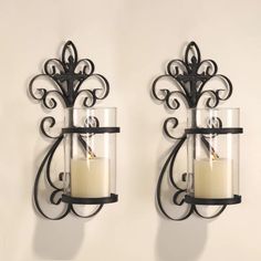 two wall sconces with candle holders on them