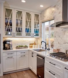 a kitchen with white cabinets and stainless steel appliances