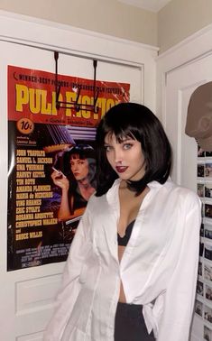 a woman standing in front of a movie poster with her hands on her hips and looking at the camera