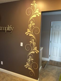 the entry way is decorated with an elegant wall decal that says simply on it