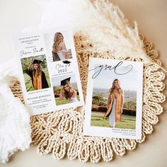 two graduation announcement cards sitting on top of a doily next to a white blanket