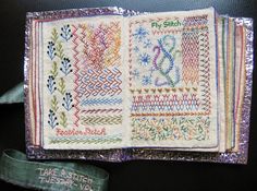 an old book with different designs on it and a ribbon tied around the cover that says fly stitch