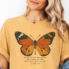 a woman wearing a yellow shirt with a butterfly on it's chest and the words, do not touch that you are