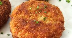 two crab cakes on a white plate with parsley