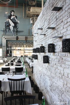 tables and chairs are set up in front of a brick wall that reads mama aki