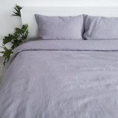 a bed with two pillows and some plants