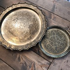 two metal plates sitting on top of a wooden table