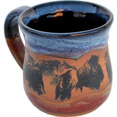 a brown and blue ceramic mug with elephants on the inside is sitting in front of a white background