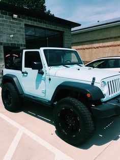 two blue jeeps parked in front of a building