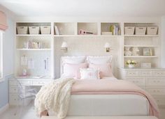 a white and pink bedroom with shelves above the bed