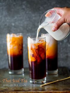 two glasses filled with iced tea sitting on top of a table