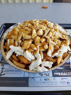 a plate full of food sitting on top of a table next to a newspaper page