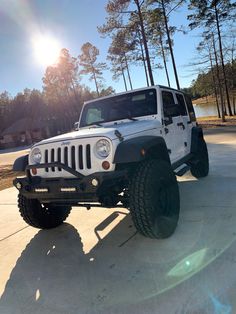 a white jeep is parked in the driveway