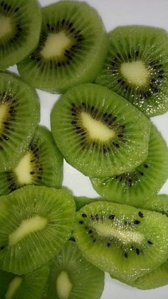 slices of kiwi are arranged on a white surface