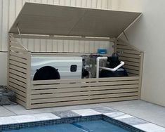 an outdoor swimming pool with a storage box on the side and a white truck in the back