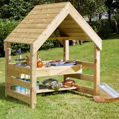 a small wooden structure with shelves in the grass