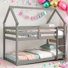 a child's bed with pink, blue and green balloons