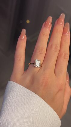 a woman's hand with a ring on it and a diamond in the middle