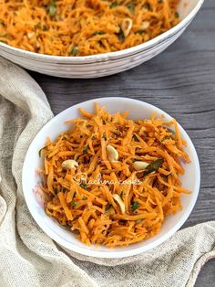 two bowls filled with carrot salad on top of a wooden table