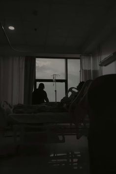 a person sitting in a hospital bed looking out the window