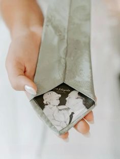 a woman is holding an old photo in her hand and it looks like she's going to be married