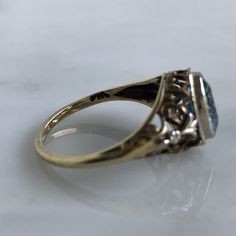 Details: Beautiful vintage aquamarine ring set in 14K yellow gold filigree. There are sweet little hearts and fleur-de-lis details. The setting looks Edwardian, with delicate yellow and white gold filigree. The pretty aquamarine measures 7.6mm x. 5.9mm. The ring sits off the finger 5.8mm. The inside is stamped 14K. Measurements: Ring measures a size 6 US. It can be re-sized for a fee. Condition: The overall all condition of this ring is very good. Please ask all questions prior to placing an ord Gold Topaz Ring With Intricate Design For Anniversary, Heirloom 14k Gold Diamond Filigree Ring, Heirloom 14k Gold Diamond Ring With Filigree, Victorian 14k Gold Topaz Ring For Anniversary, Vintage Oval Topaz Ring With Intricate Design, Antique 14k Gold Filigree Ring With Rose Cut Diamonds, Vintage 14k Gold Filigree Diamond Ring, Vintage 14k Gold Diamond Ring With Filigree, Vintage White Gold Filigree Ring In 14k