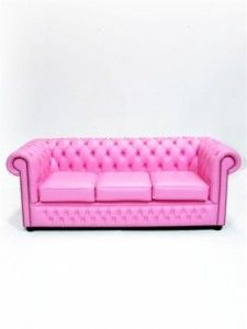 a pink couch sitting on top of a white floor