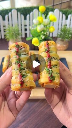 two hands holding up small sandwiches with toppings on them