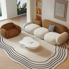 a modern living room with two couches and a coffee table on top of the rug