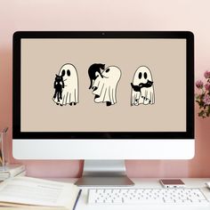 a computer screen with three ghost characters on it, sitting next to a keyboard and mouse